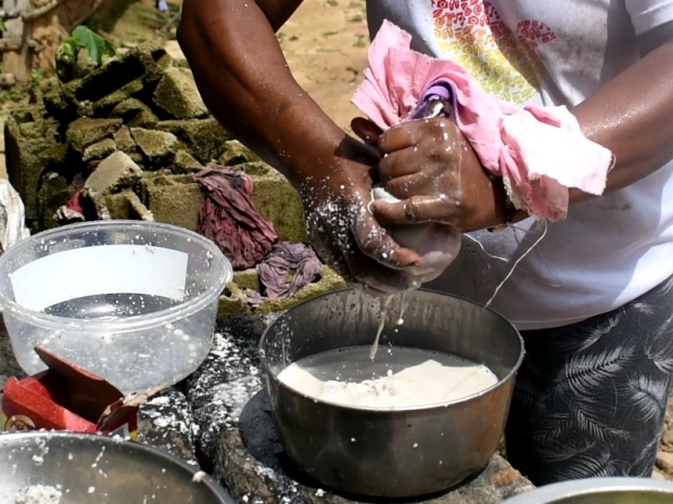 Proceso de colado de la leche de corozo utilizando un paño.